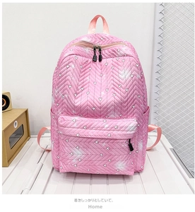 Detalle de mochila rosa acolchada con corazones, costuras en V y cremallera doble