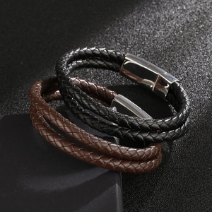 Close-up of black and dark brown woven leather bracelets with magnetic steel clasps