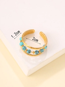 Macro detail of Egyptian style gold ring with turquoise beads and hammered texture
