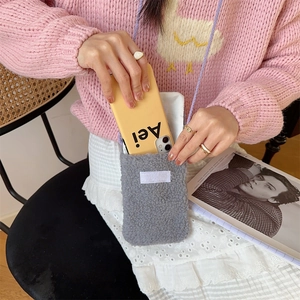 Detail of gray plush crossbody phone bag with purple strap and soft teddy fleece texture