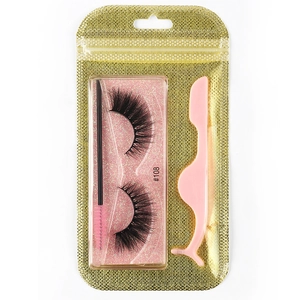Macro view of 3D dense false eyelashes with pink brush and applicator in gold glitter bag