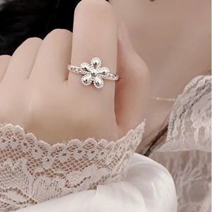 Detailed close-up of a silver sunflower ring featuring intricate beaded edges and cut-out band