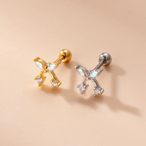 Detail view of gold and silver mini bow earrings with cubic zirconia and screw backs