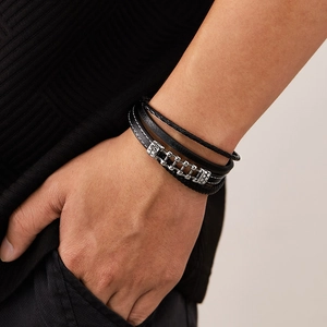 Detail of multi-layer black braided leather bracelet with silver magnetic metal clasp