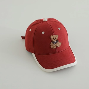 Détail de la broderie ours et du liseré blanc sur la casquette rouge pour enfants
