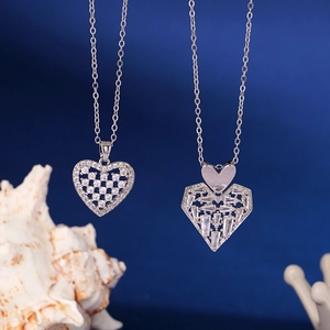 Dual heart-shaped zirconia pendants on silver chains over a deep blue elegant background