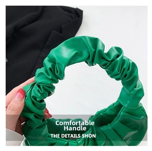 Detail view of the bright green pleated handle on this stylish cloud-shaped handbag