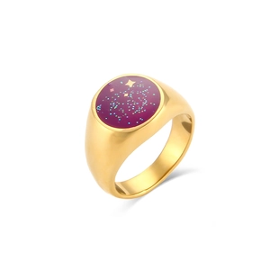 Dettaglio dell'anello ovale dorato con smalto viola e motivi a stella dorati glitterati