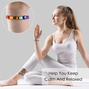 Detail of 7 chakra bracelet on female wrist during yoga with a material close-up