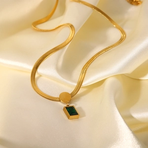 Detail of 18K gold stainless steel snake chain featuring a green square zircon pendant