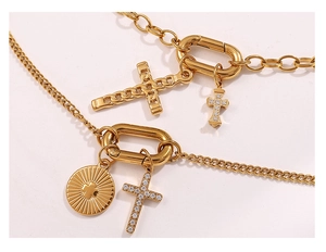 Close-up of double-layer gold cross necklace with pavé zircon and sunburst pendant