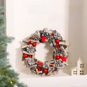 Christmas wreath with red ornaments, wood blocks, and pinecones on a white fireplace mantel