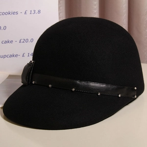 Close-up of black wool equestrian hat featuring a rhinestone leather band and bow detail
