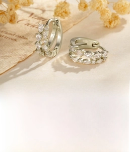 Vue macro de boucles d'oreilles doubles rangées de zircons avec finition or café rétro