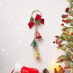 Christmas bell ornament with rope, red bow and pine needles for festive wall decoration