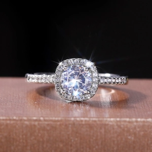 Close-up of sparkling halo engagement ring with round center diamond and pavé band
