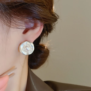 Dettaglio di orecchini in metallo fuso argento con perla d'acqua dolce su una modella
