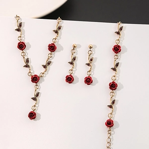 Close-up of vintage red rose jewelry set including necklace, earrings and bracelet