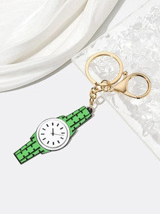 Detail of green and white watch-shaped keychain with gold lobster clasp on white satin