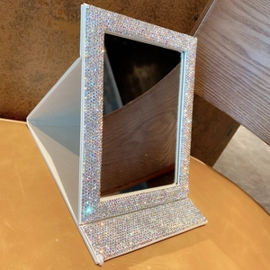 Detail view of foldable makeup mirror with colorful rhinestones and white PU leather base