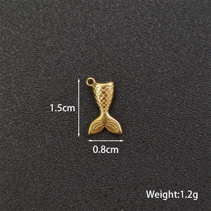 Macro view of gold fishtail pendant showing dimensions 1.5cm by 0.8cm and 1.2g weight