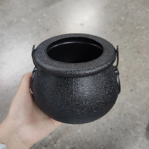 Close-up of a black matte cauldron candy bucket with handles for Halloween props