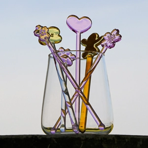 Heat-resistant glass drink stirrers with heart and gingerbread man tops in a cup