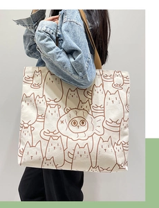 Detail of white canvas tote bag with cat and fish print and comfortable wide shoulder strap