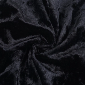 Macro shot of premium black velvet fabric showing natural folds and elegant texture