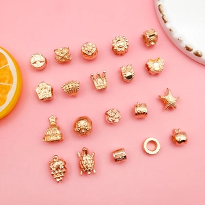 Detail of assorted gold alloy large hole beads featuring star, crown and shell shapes