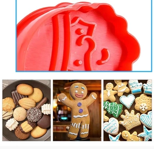 Close-up of red plastic cookie mold sets and diverse shaped finished holiday biscuits