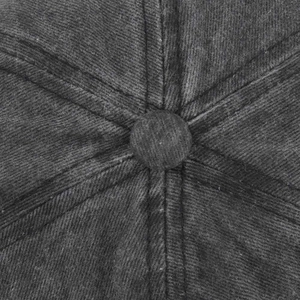 Detail of a dark grey washed cotton baseball cap showing top button and six-panel stitching