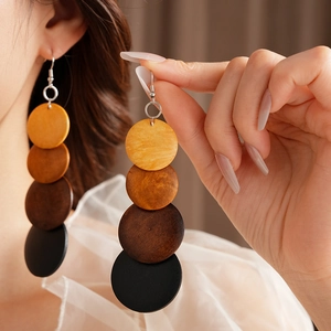 Macro shot of tiered bohemian wooden disc earrings with dark brown gradient wood texture