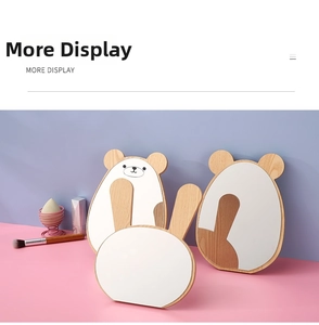 Detail shot of cute wooden cartoon bear and rabbit desktop vanity mirrors on soft backdrop