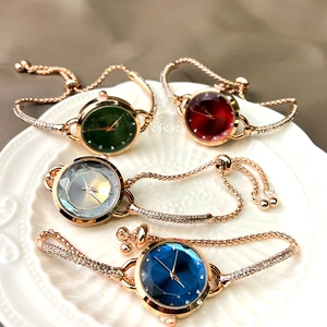 Close-up of four fashion watches with rose gold link bracelets and faceted gem-style dials
