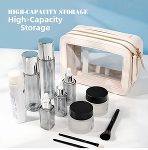 Close-up of beige leather toiletry bag with clear PVC window and gold double zippers