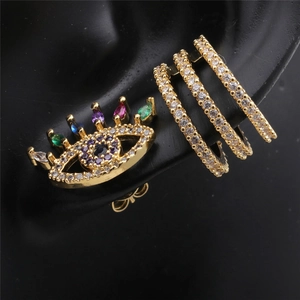Gold Evil Eye stud earrings and layered cuff set with colorful cubic zirconia on black model