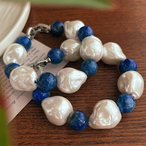Macro shot of baroque pearls and blue lapis lazuli beads with S925 silver clasp detail