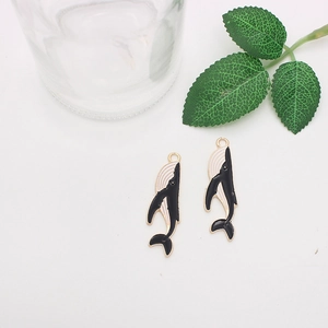 Detail of whale-shaped enamel charms with gold edges for DIY jewelry making