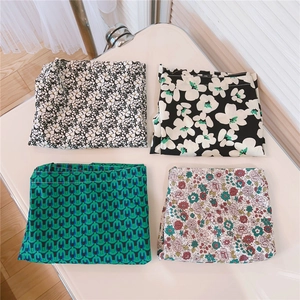 Close-up of four floral and geometric patterns on soft green cotton fabric bags