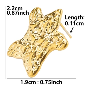 Detail view of golden star earring showing size 2.2cm height and hammered metal texture
