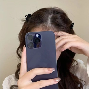 Detail view of two small black floral hair claws worn for a retro princess hairstyle look