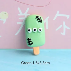 Macro shot of green monster popsicle resin charm with 3 eyes for DIY crafts and 1.6x3.3cm size
