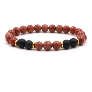 Detail of 8mm tiger eye and matte black beaded elastic bracelet with gold spacers