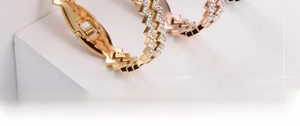 Close-up of rose gold wave bangle featuring pavé-set crystals and hinge closure detail