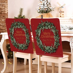 Detail of red Christmas chair covers featuring green wreaths and holiday greetings