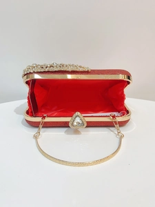 Macro detail of red glitter evening clutch with red satin lining and golden frame