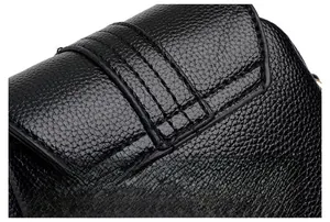 Detail of lychee pattern leather and neat stitching on black crossbody phone bag