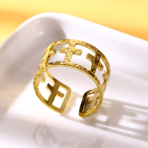 Detail of hammered gold-plated stainless steel ring featuring cutout cross patterns
