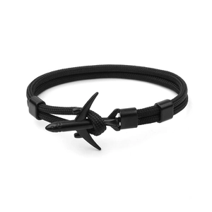 Detail of black woven paracord bracelet featuring a sleek black metal airplane clasp